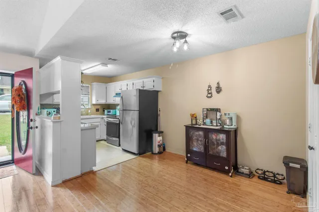 a view of kitchen with refrigerator and wooden floor