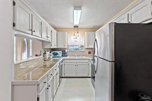 a kitchen with stainless steel appliances a refrigerator sink and cabinets
