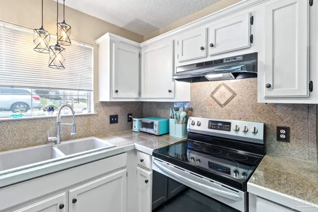 a kitchen with stainless steel appliances granite countertop a sink stove and cabinets