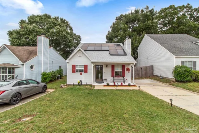 a front view of a house with a garden and trees