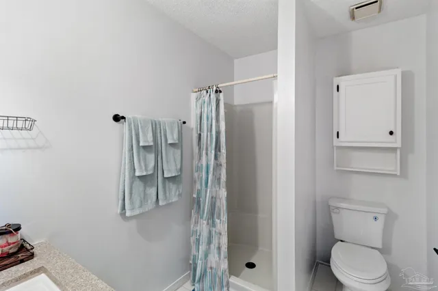 a bathroom with a shower a toilet and a sink