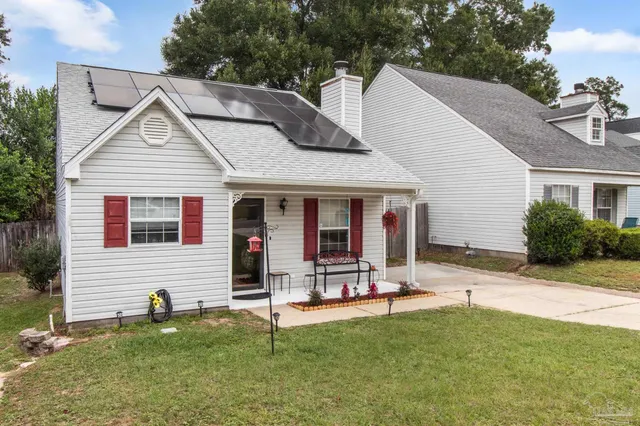 a view of house with a yard and sitting area