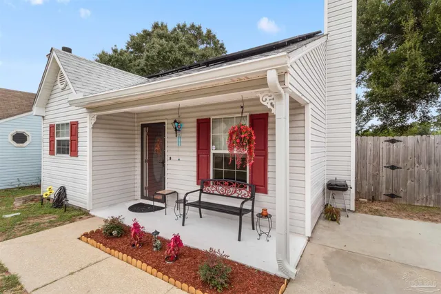 a view of a patio with a table and chairs and a barbeque