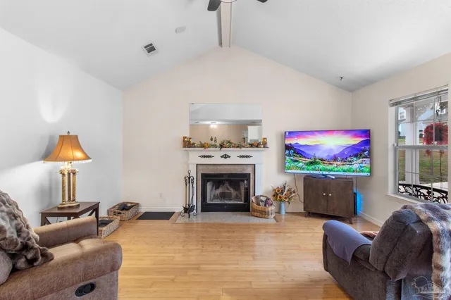 a living room with furniture a fireplace and a flat screen tv