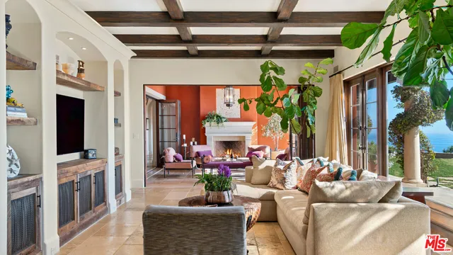 a living room with furniture a fireplace and a chandelier