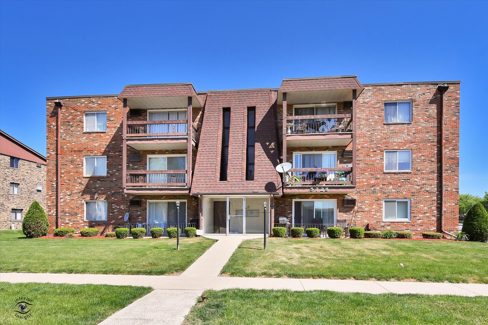 a front view of a building with a garden
