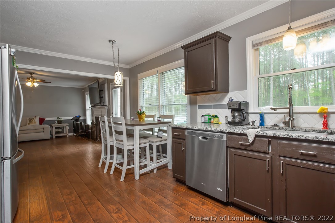7156 Rockfish Road Raeford, NC 28376 - Photo 11 of 27 a kitchen with sink cabinets and dining table