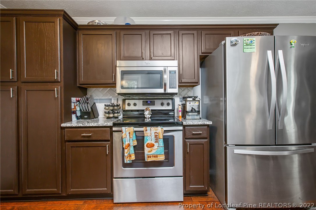 7156 Rockfish Road Raeford, NC 28376 - Photo 12 of 27 a kitchen with stainless steel appliances a refrigerator stove and microwave