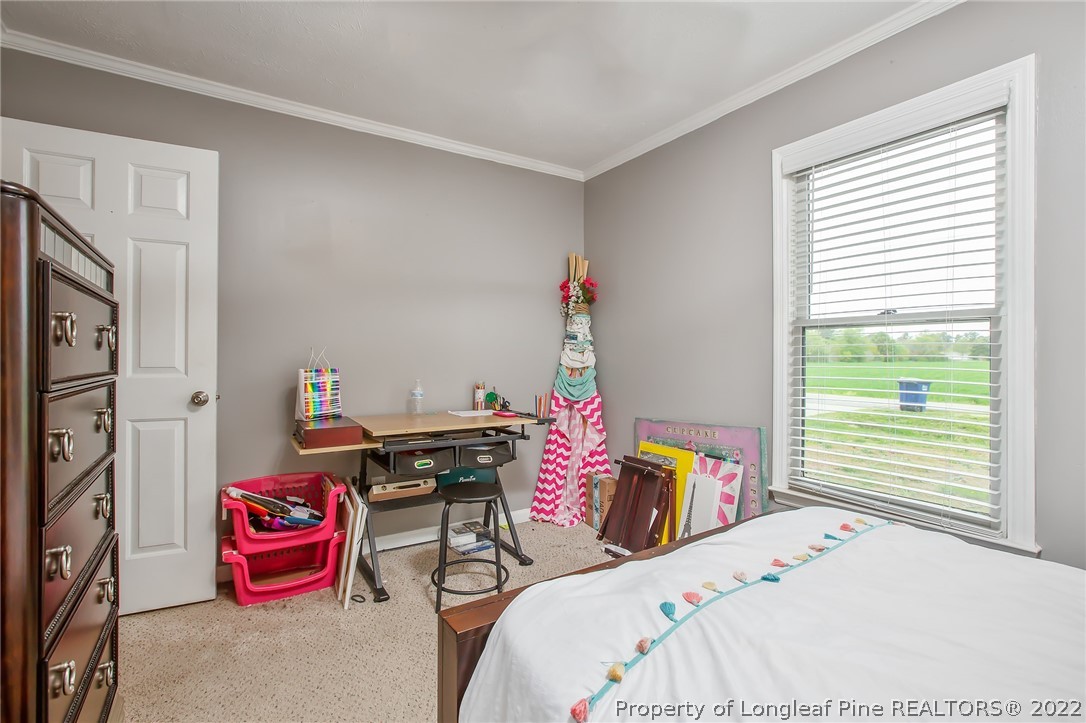 7156 Rockfish Road Raeford, NC 28376 - Photo 17 of 27 a bedroom with a bed and a table