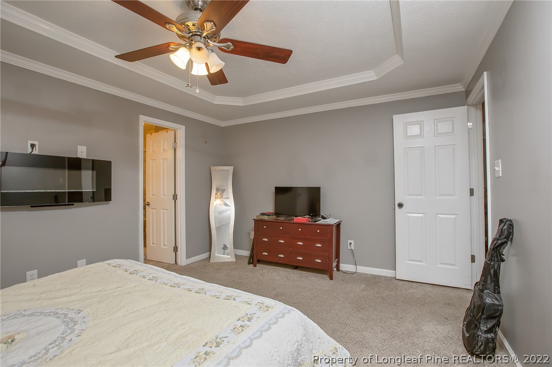 7156 Rockfish Road Raeford, NC 28376 - Photo 25 of 27 a bedroom with a bed and a chandelier