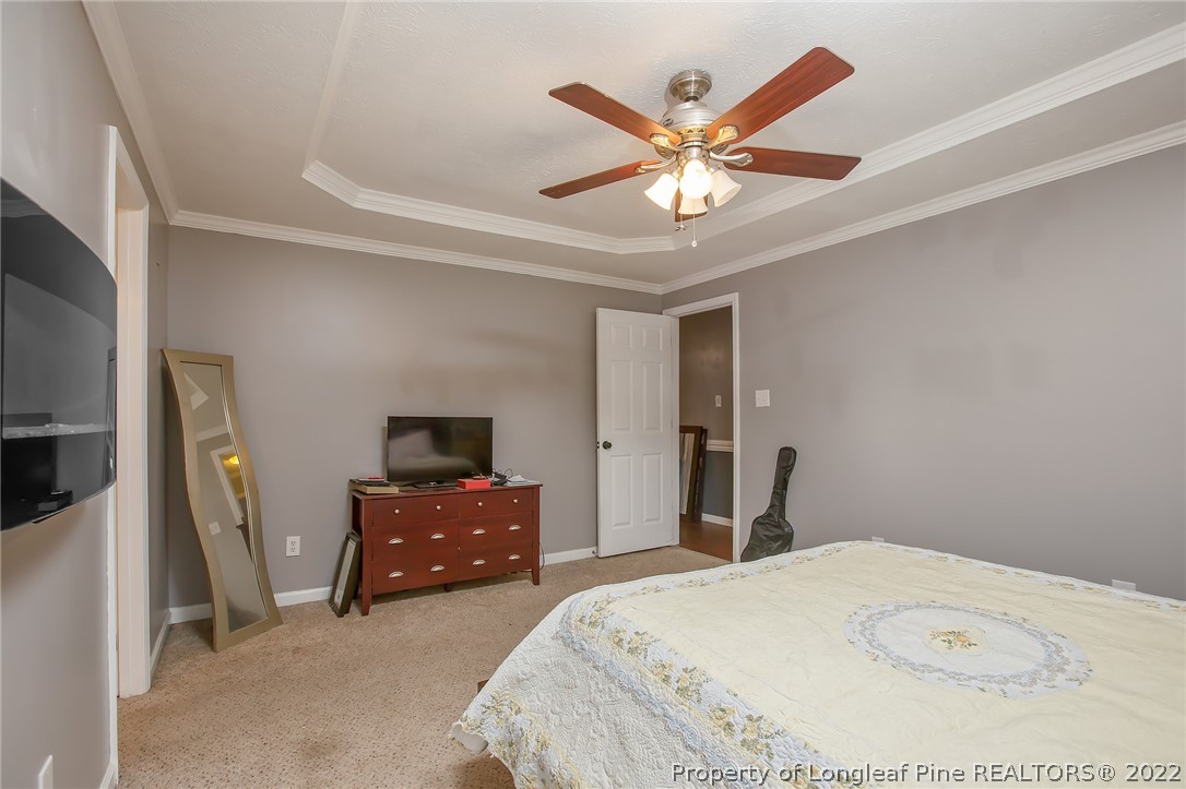 7156 Rockfish Road Raeford, NC 28376 - Photo 26 of 27 a bedroom with a bed and a chandelier