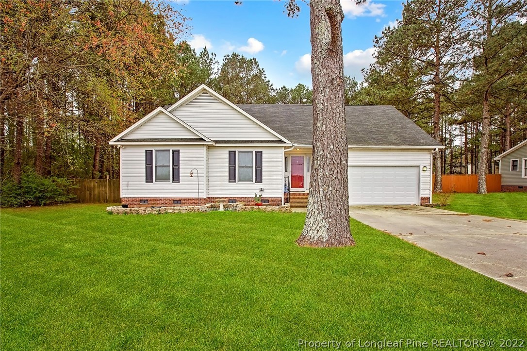 7156 Rockfish Road Raeford, NC 28376 - Photo 3 of 27 a front view of a house with a garden and yard