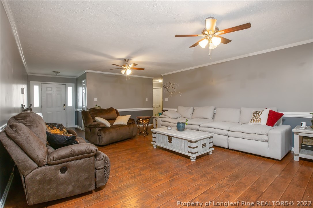 7156 Rockfish Road Raeford, NC 28376 - Photo 9 of 27 a living room with furniture and a chandelier