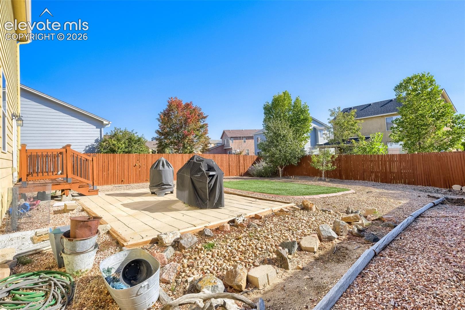 10149 Angeles Road Peyton, CO 80831 - Photo 19 of 24 Expansive backyard featuring a wood-plank patio, wooden deck, full privacy fence, and a manicured lawn area