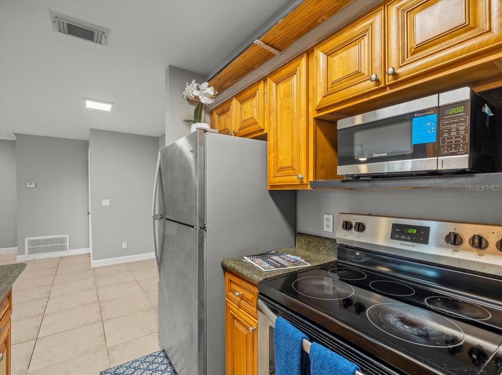 230 Thorntree Place, Unit 230 Brandon, FL 33510 - Photo 11 of 49 a kitchen with a stove and a refrigerator