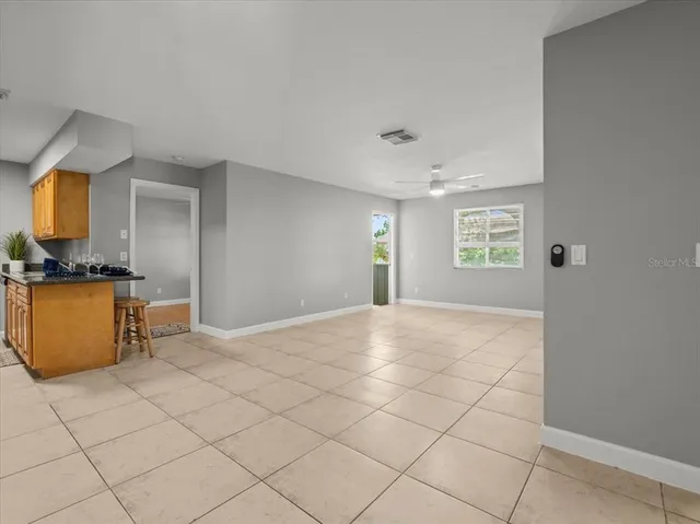 a view of an empty room and a chandelier fan
