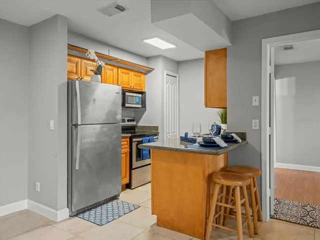 a kitchen with a refrigerator a stove and a dining table