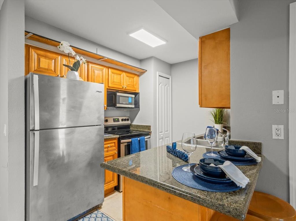 230 Thorntree Place, Unit 230 Brandon, FL 33510 - Photo 6 of 49 a kitchen with a refrigerator and a stove top oven