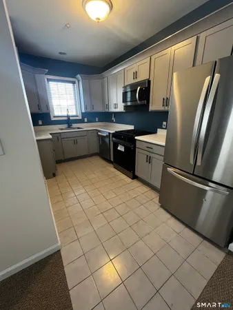 a kitchen with stainless steel appliances a refrigerator sink and microwave