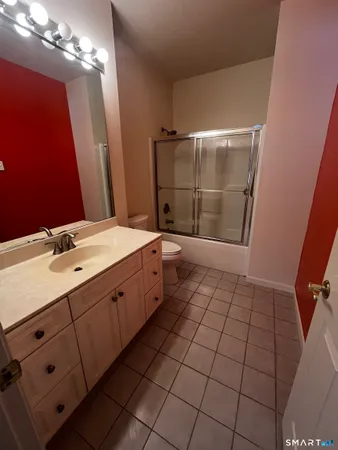 a spacious bathroom with a double vanity sink a toilet and a mirror