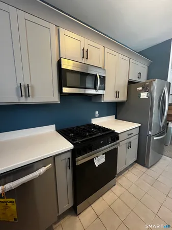 a kitchen with stainless steel appliances a stove microwave and refrigerator
