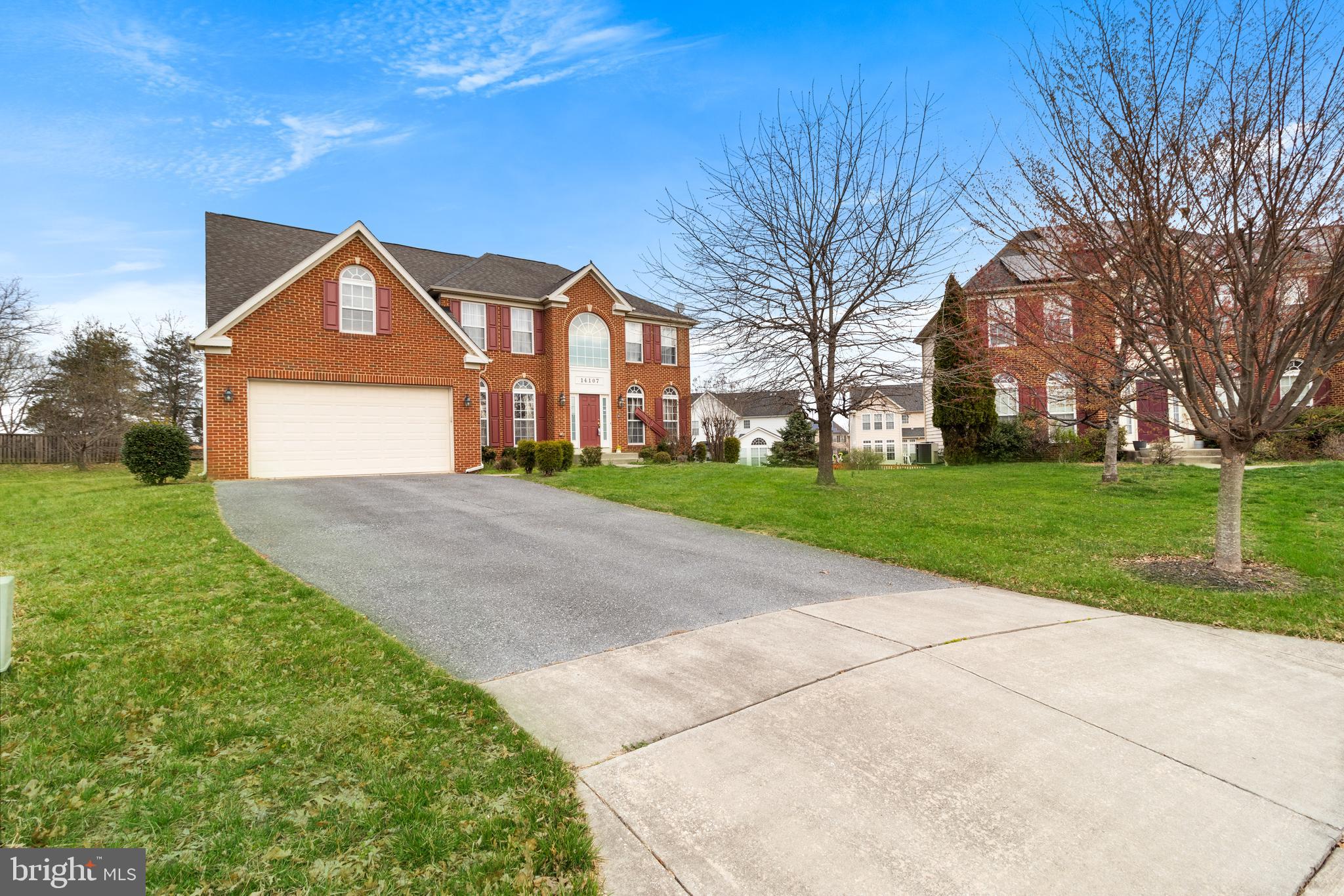 a front view of a house with yard and green space