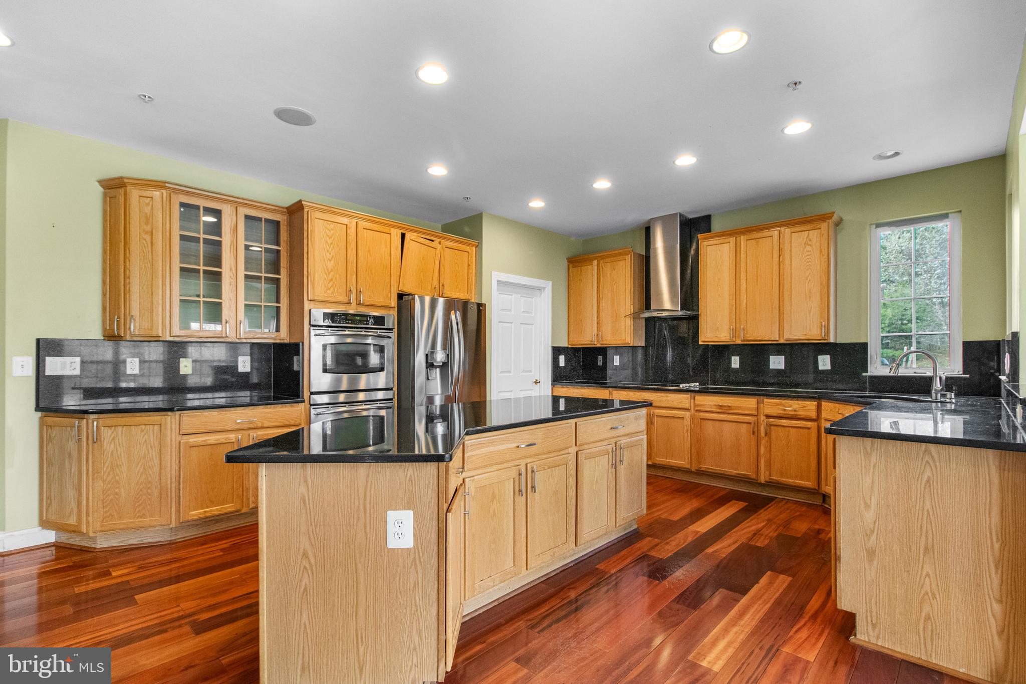 14107 Mintlaw Landing Laurel, MD 20707 - Photo 23 of 63 a large kitchen with stainless steel appliances lots of counter top space and wooden floor