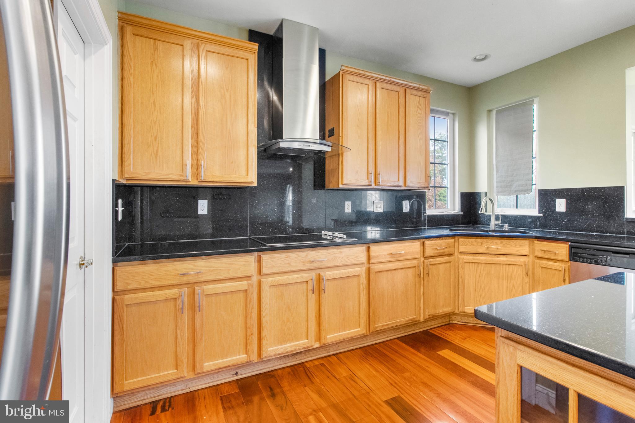 14107 Mintlaw Landing Laurel, MD 20707 - Photo 25 of 63 a kitchen with stainless steel appliances granite countertop wooden cabinets a sink and a large window