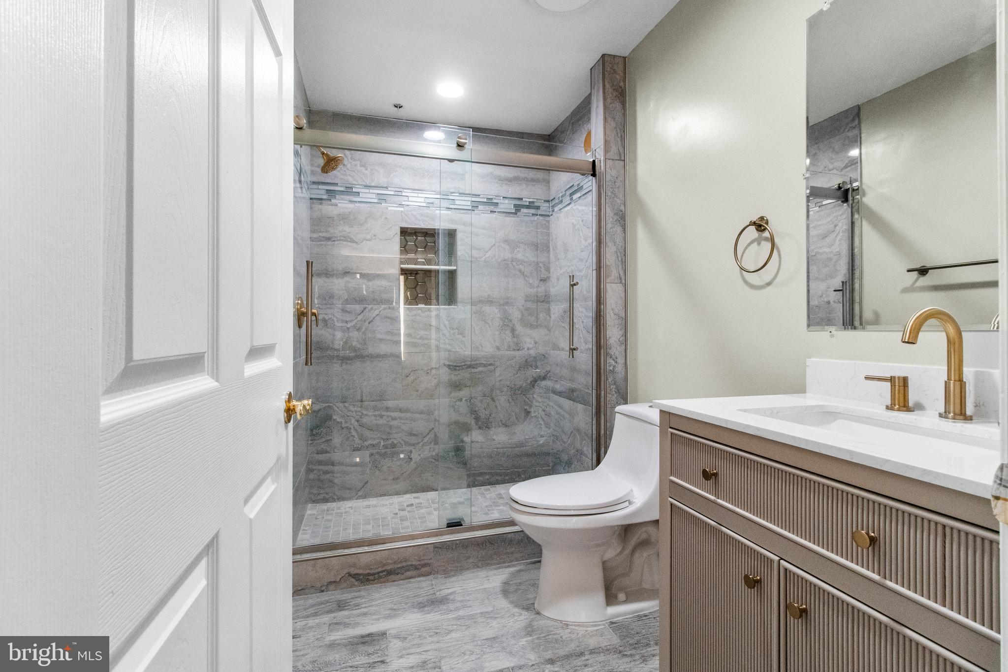 14107 Mintlaw Landing Laurel, MD 20707 - Photo 31 of 63 a bathroom with a granite countertop sink toilet and shower