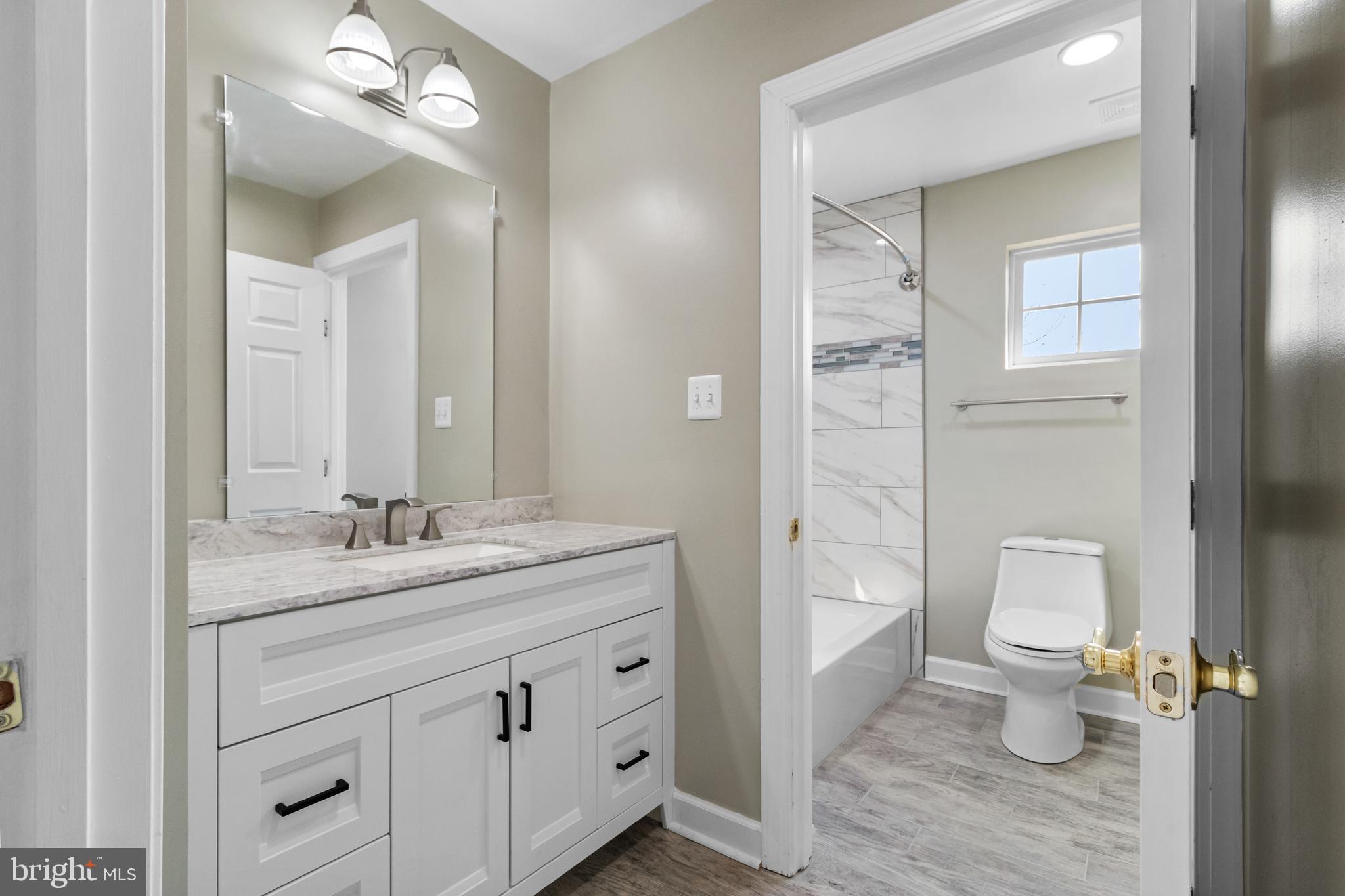 14107 Mintlaw Landing Laurel, MD 20707 - Photo 34 of 63 a bathroom with a toilet a sink and a large mirror