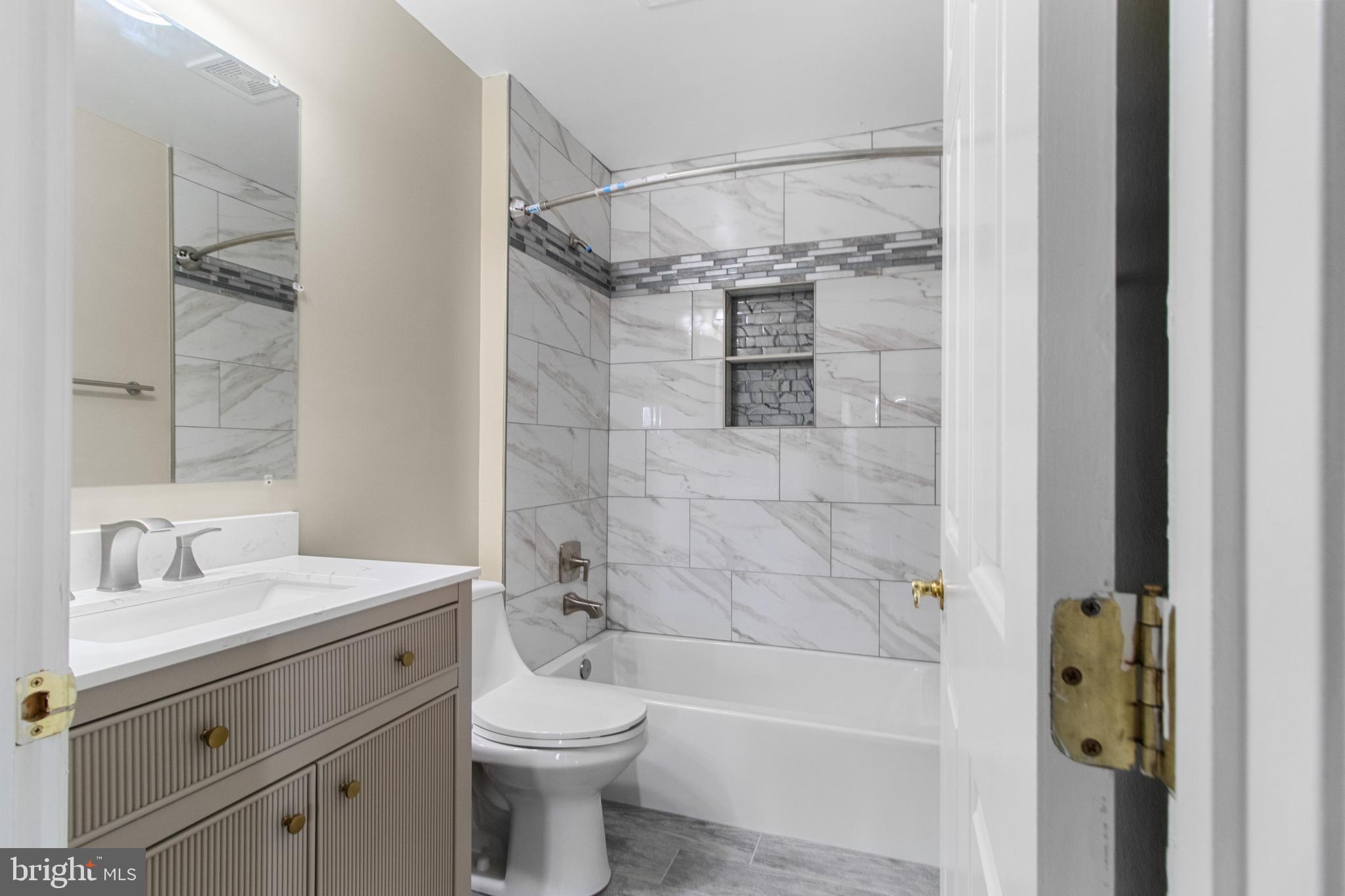 14107 Mintlaw Landing Laurel, MD 20707 - Photo 47 of 63 a bathroom with a shower a sink a toilet and a mirror