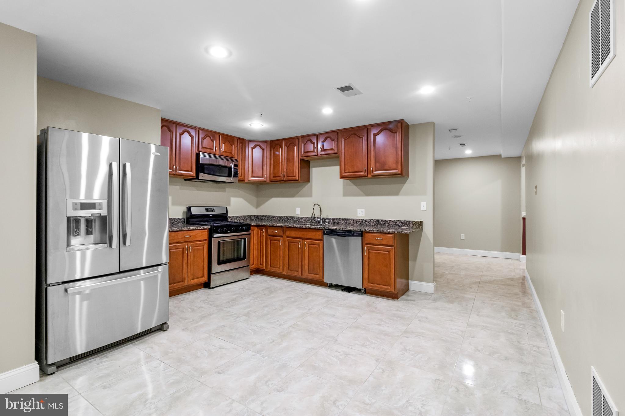14107 Mintlaw Landing Laurel, MD 20707 - Photo 58 of 63 a kitchen with stainless steel appliances granite countertop a refrigerator and a sink