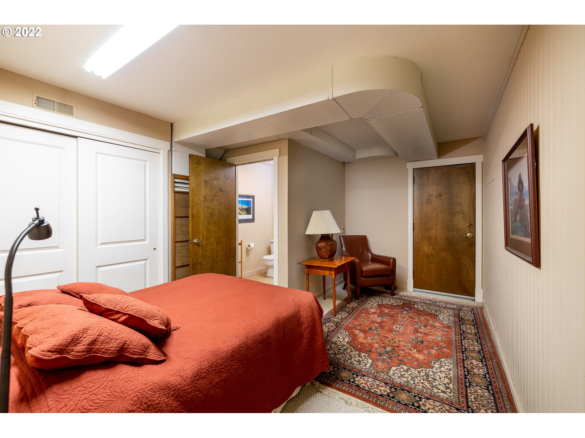 3096 Northeast East Line Road Yachats, OR 97498 - Photo 23 of 30 a bedroom with a bed and a chandelier