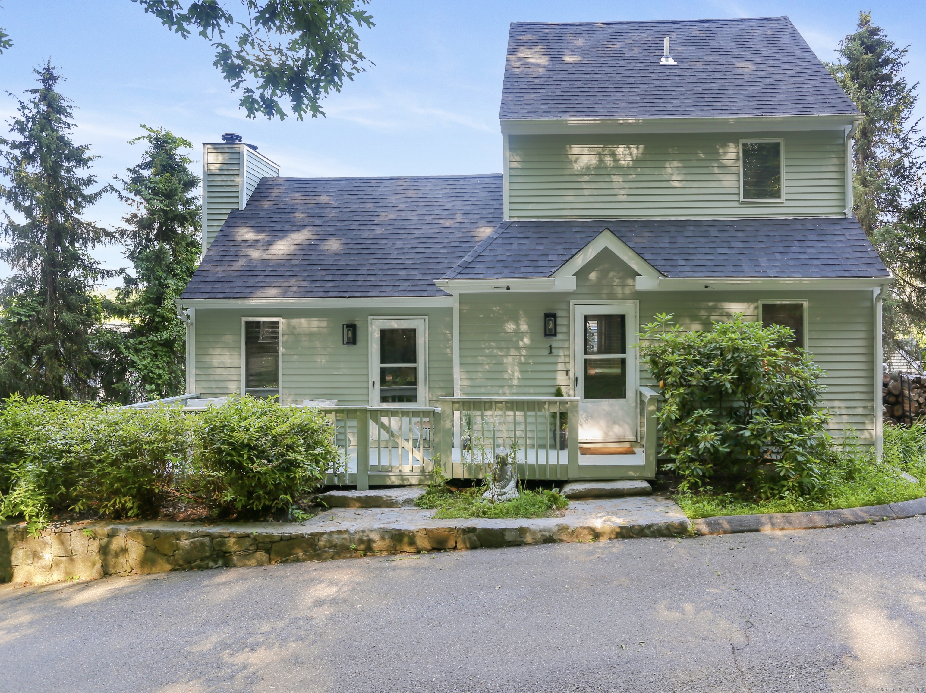21 Hubbard Road, Unit 1 Wilton, CT 06897 - Photo 1 of 1 a front view of a house with a yard and garage