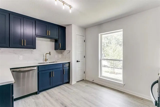 a kitchen with granite countertop wooden cabinets stainless steel appliances a sink and a window