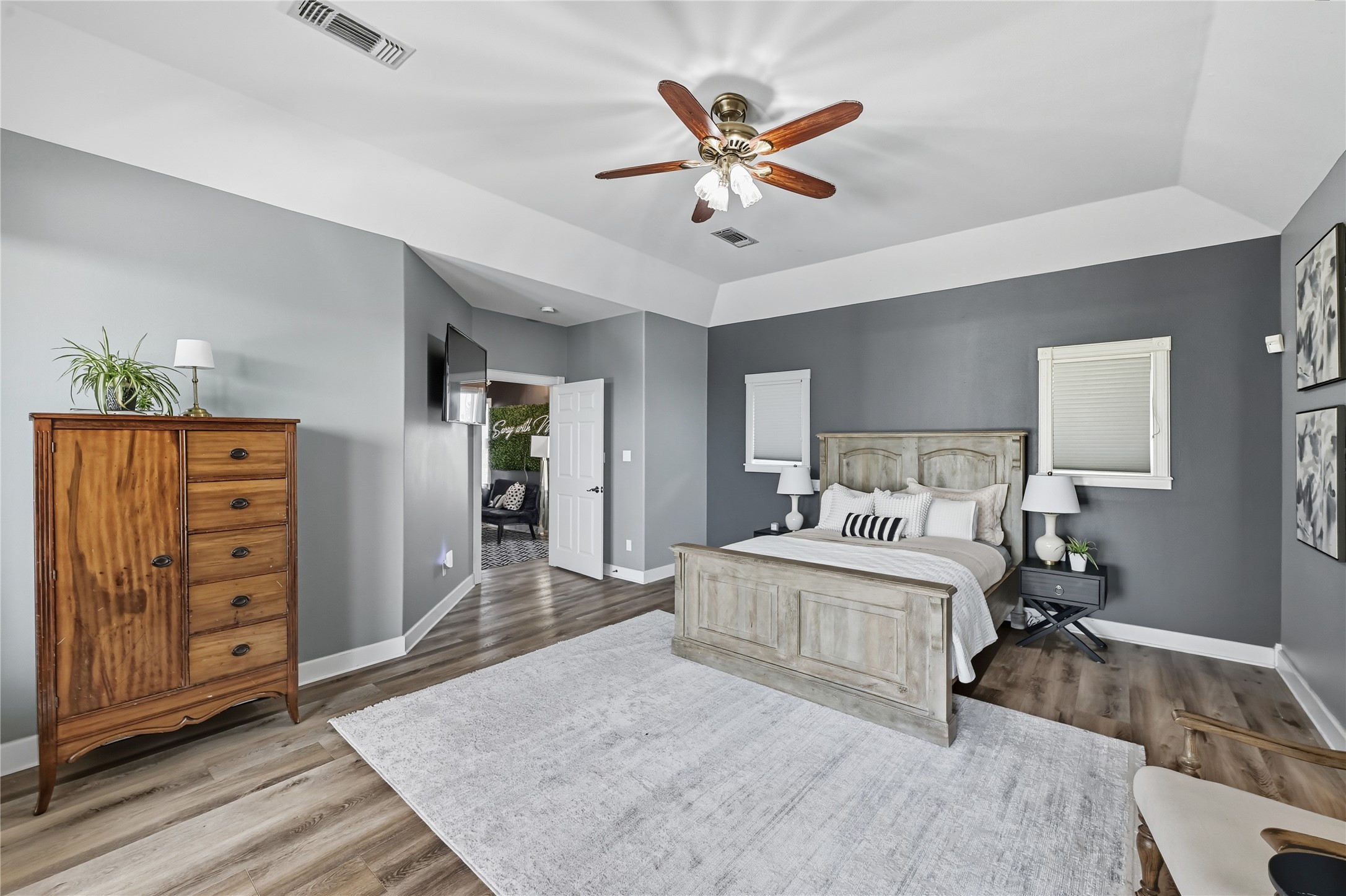 8075 Mt Sharp Road Wimberley, TX 78676 - Photo 14 of 30 a bedroom with a large bed a chandelier and dresser