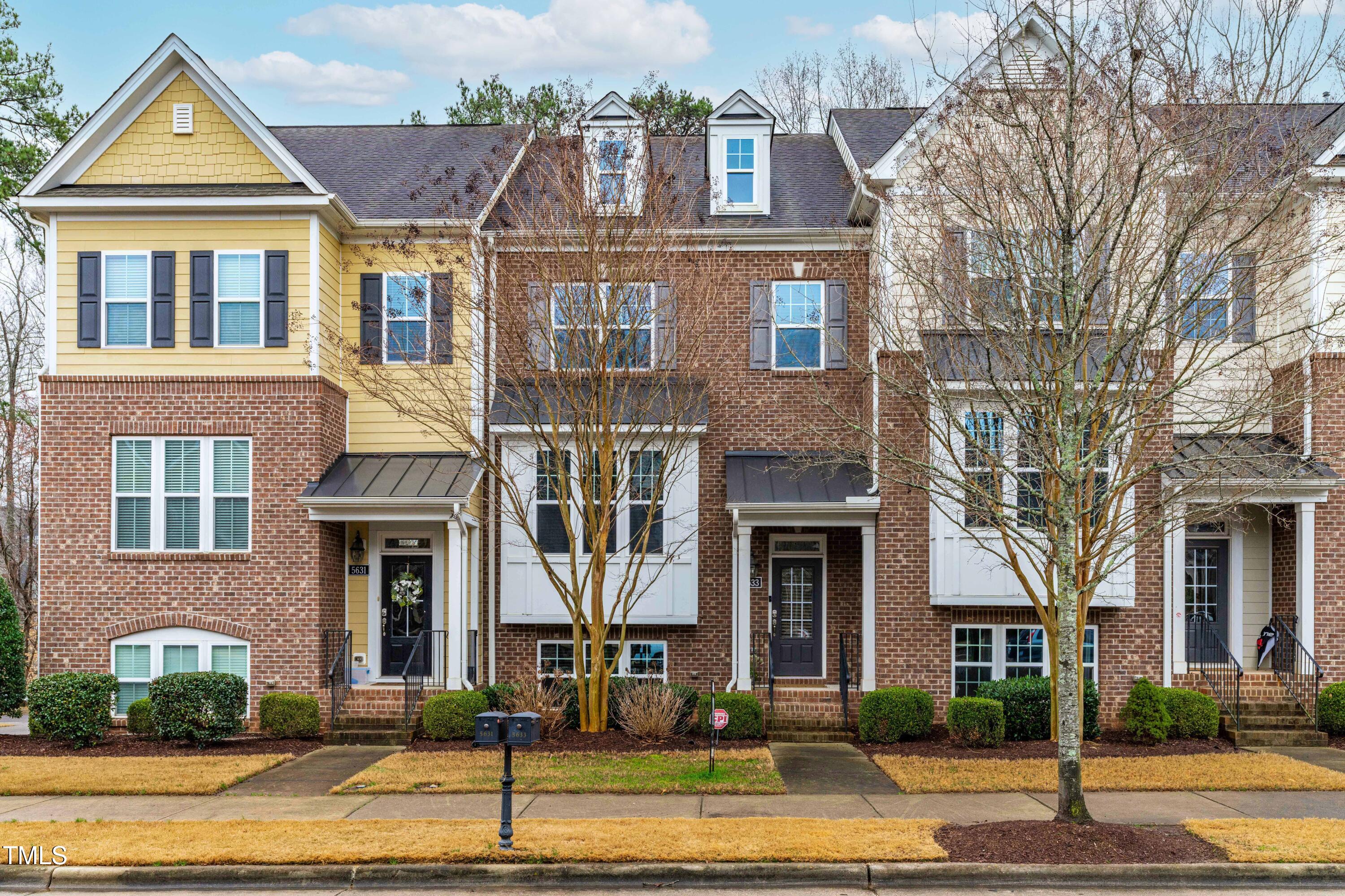 5633 Wade Park Boulevard Raleigh, NC 27607 - Photo 5 of 34 a view of a brick house with many windows and a yard
