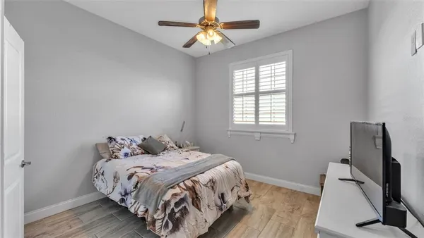a bedroom with a bed and a flat tv screen on the dresser