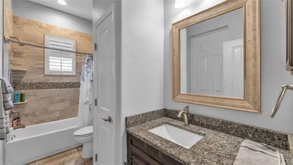 a bathroom with a granite countertop sink toilet and shower