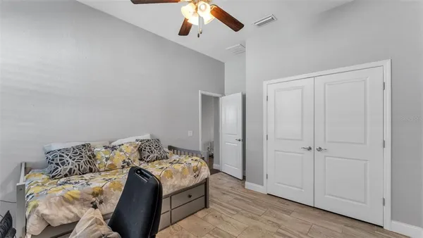 a bedroom with a bed and a ceiling fan
