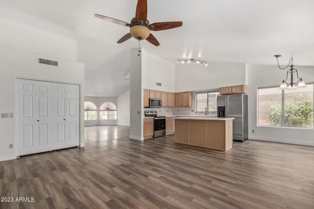 an empty room with wooden floor fireplace and windows