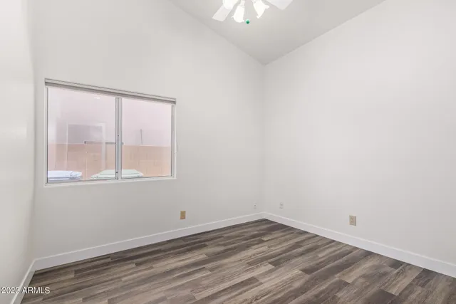 a view of an empty room with closet and wooden floor