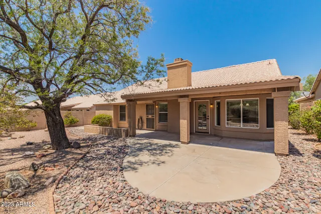 a backyard of a house with fire pit and trees