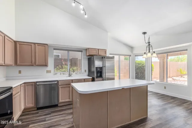 a kitchen with stainless steel appliances granite countertop a sink stove and refrigerator
