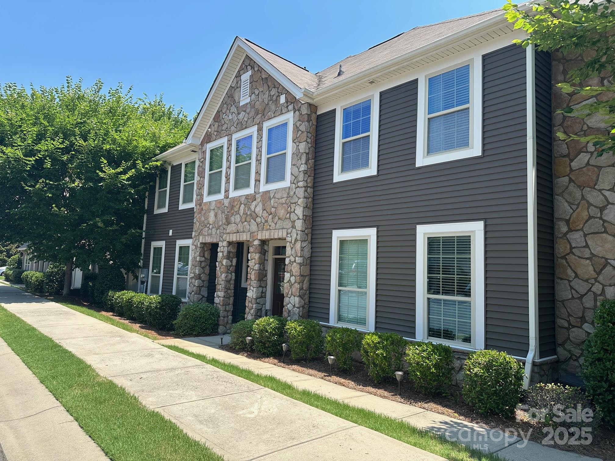 a front view of a house with yard and green space