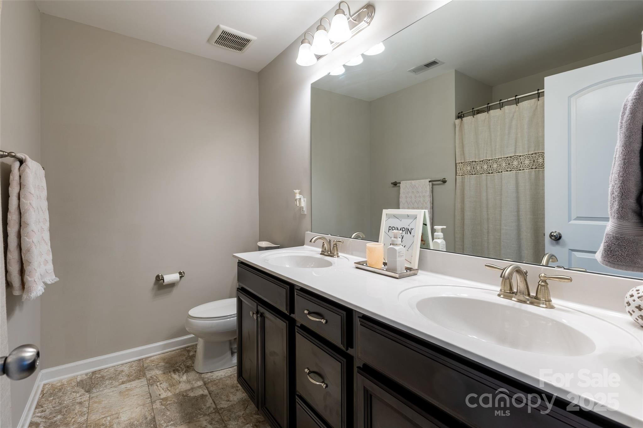 1019 Archibald Avenue Fort Mill, SC 29708 - Photo 21 of 26 a bathroom with a granite countertop sink a large mirror and a toilet