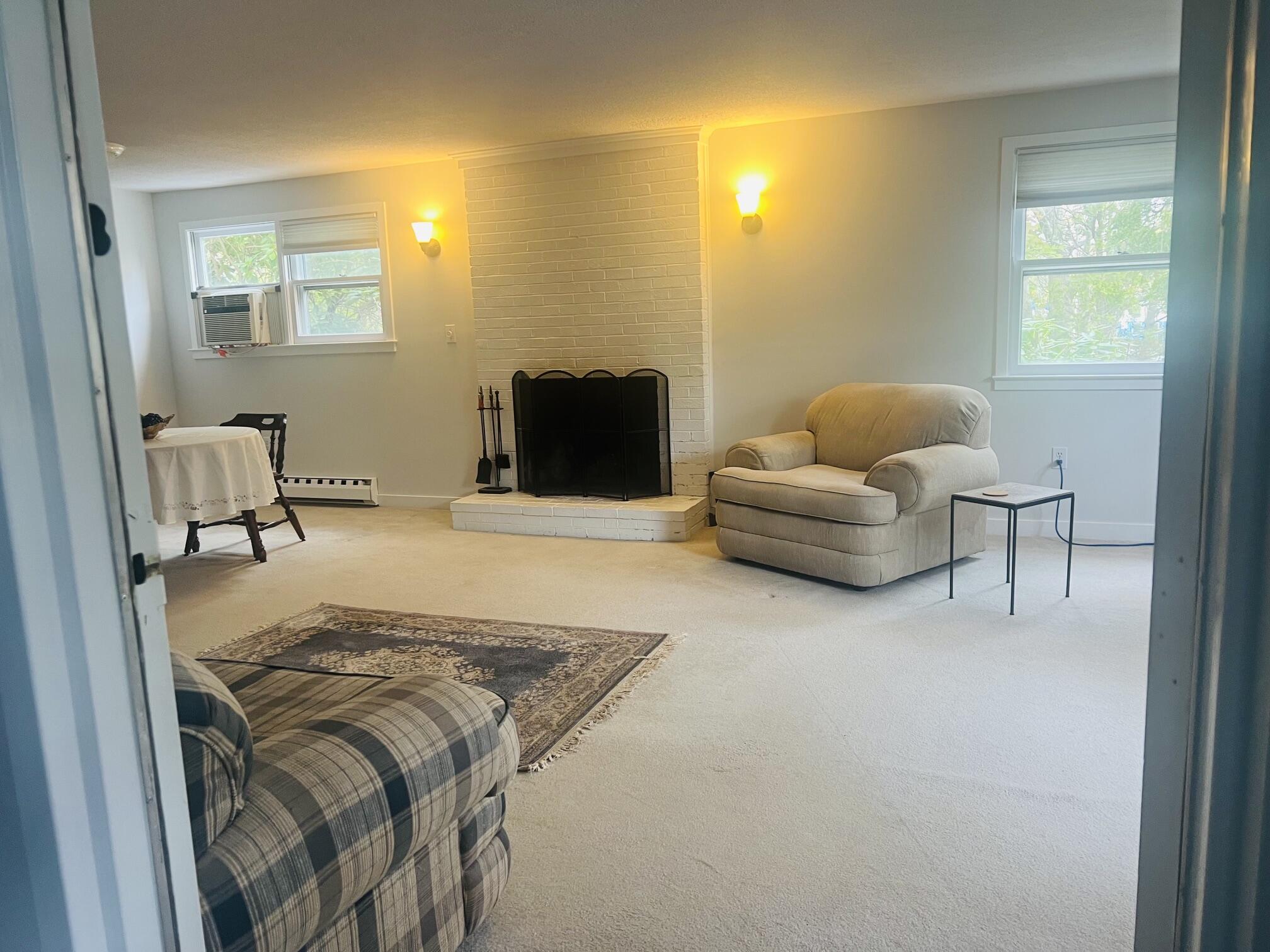 1431 Iyannough Road, Unit 1 Centerville, MA 02632 - Photo 3 of 28 a bedroom with a bed and a chair