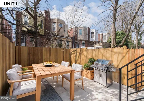 a backyard of a house with table and chairs