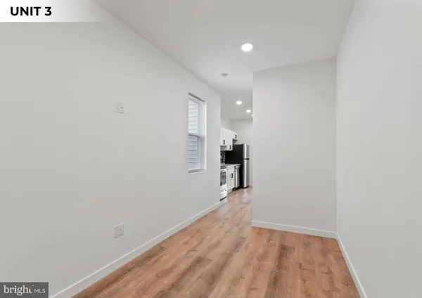 a view of empty room with wooden floor