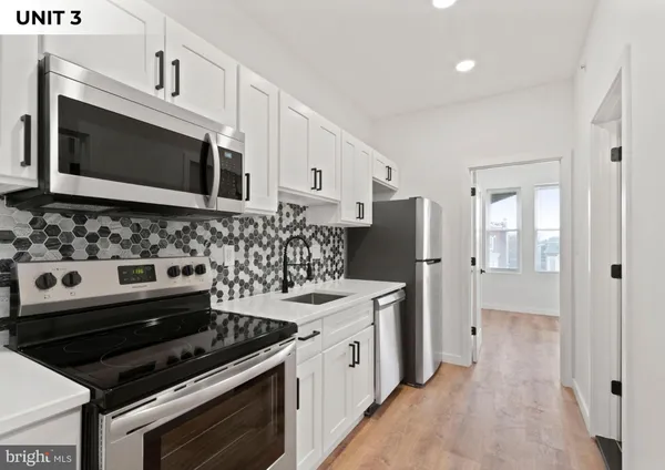 a kitchen with stainless steel appliances a stove microwave and refrigerator